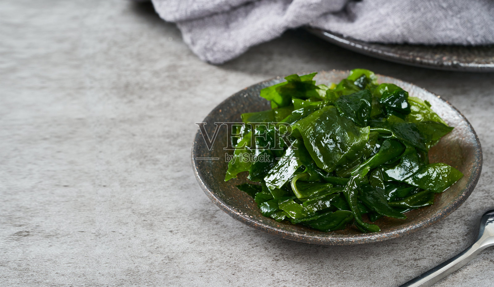 在带有复制空间的灰色背景上，靠近碗中的海带(海带)海藻照片摄影图片