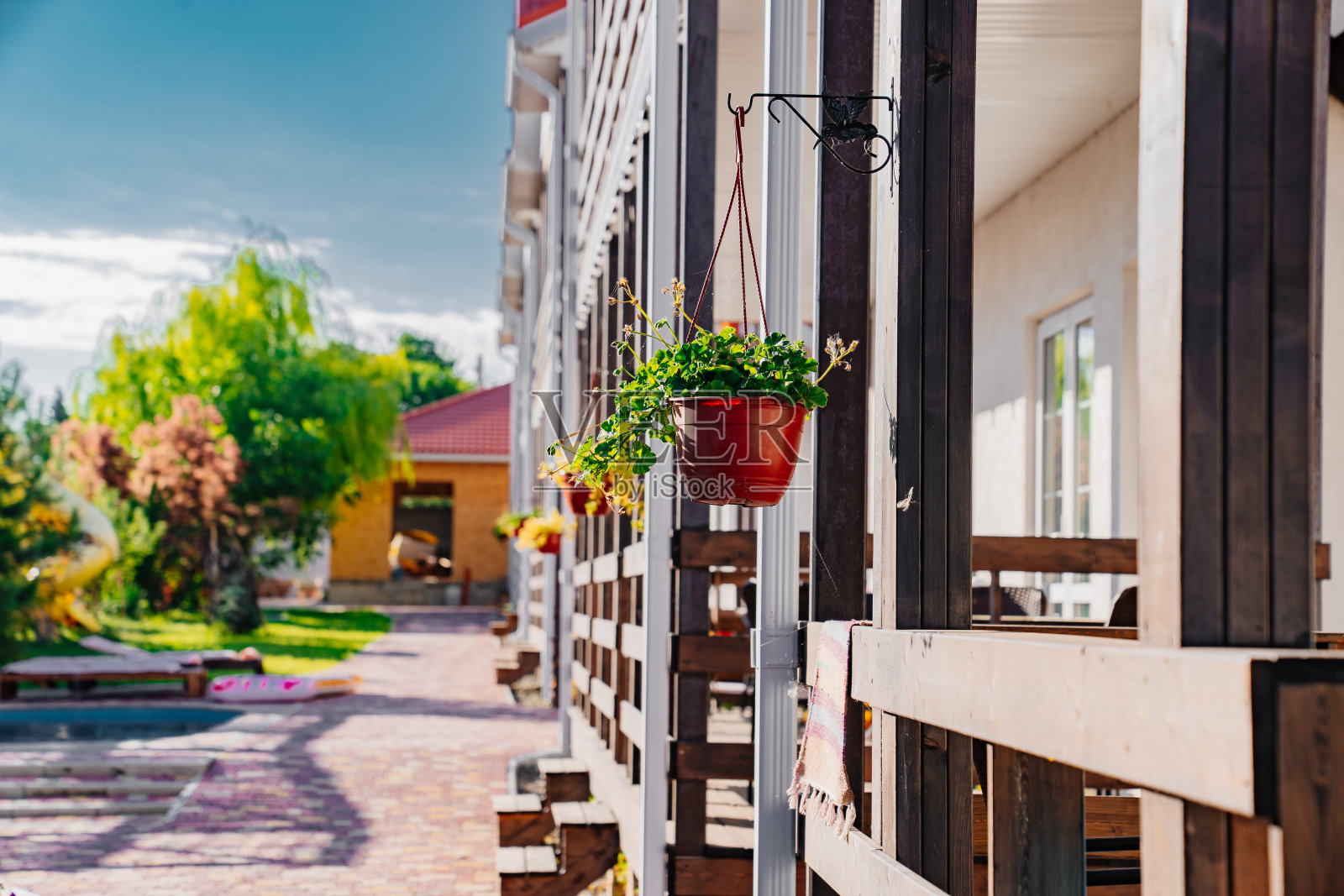 门廊上的花盆里挂着花。照片摄影图片