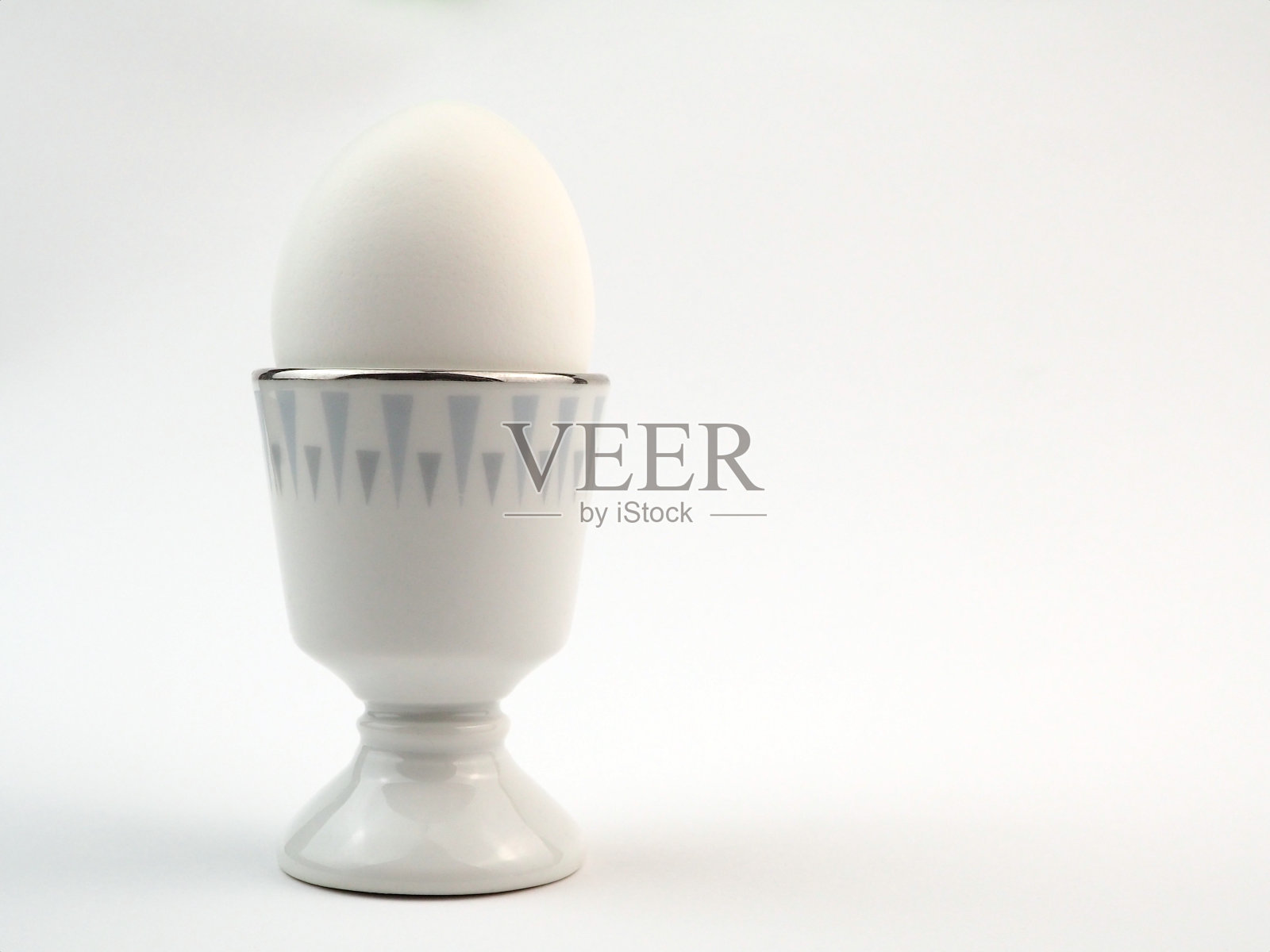 煮熟的白鸡蛋在一个站，孤立在白色的背景照片摄影图片