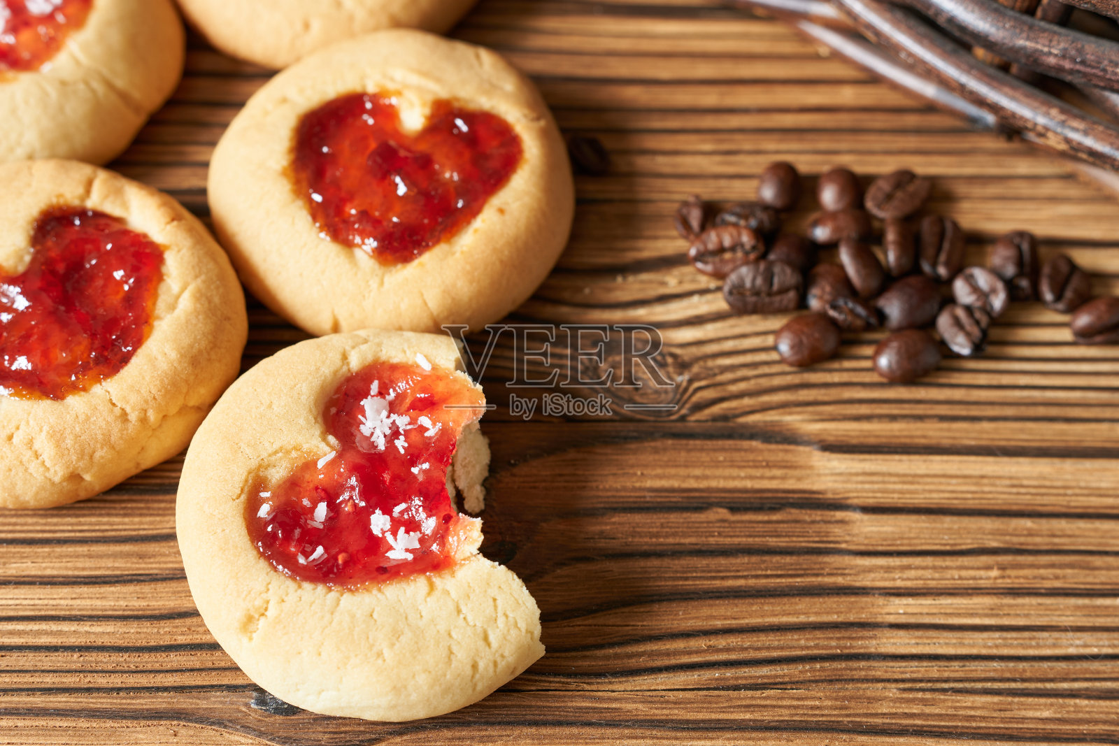 木质背景上有心形和咖啡豆的沙质曲奇。照片摄影图片