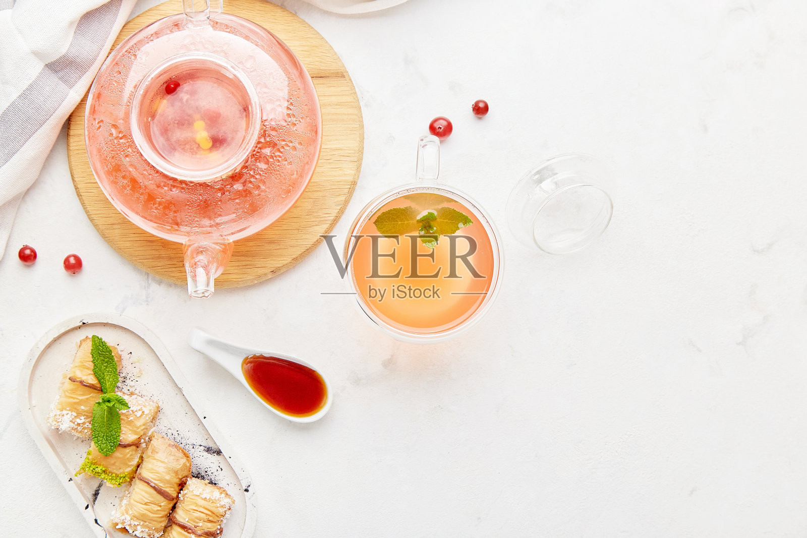 蔓越莓茶、土耳其蜂蜜果仁蜜饼和薄荷玻璃茶壶照片摄影图片