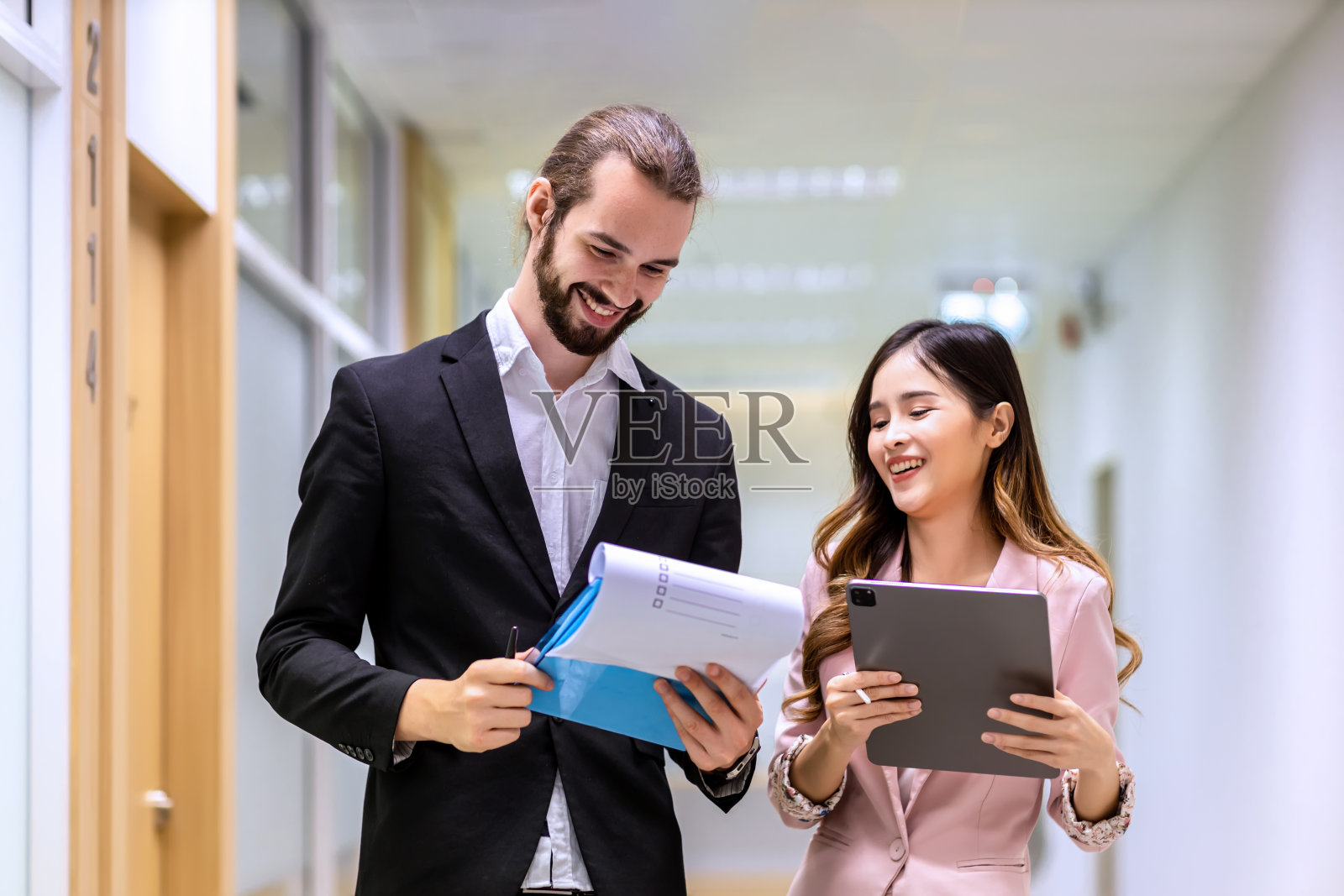 不同的朋友，合作伙伴，同事，在现代化的办公室走廊上聊天。照片摄影图片