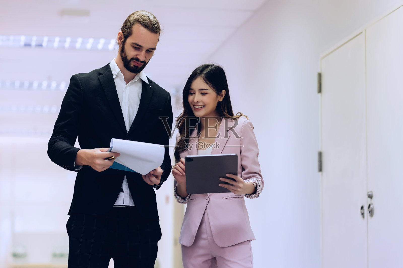 不同的朋友，合作伙伴，同事，在现代化的办公室走廊上聊天。照片摄影图片