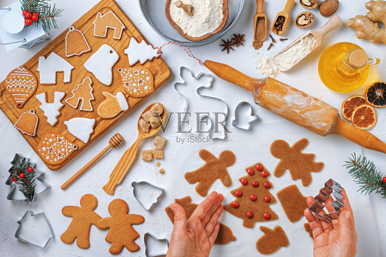 圣诞姜饼形状各异，配料为姜饼和女面包师的手，俯视图，平铺照片摄影图片