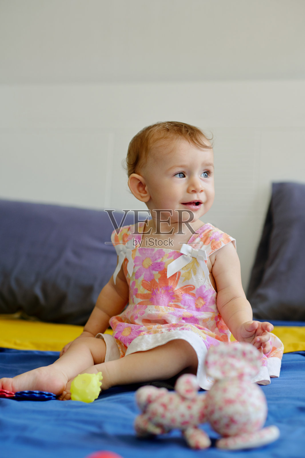 小女孩坐在床上照片摄影图片