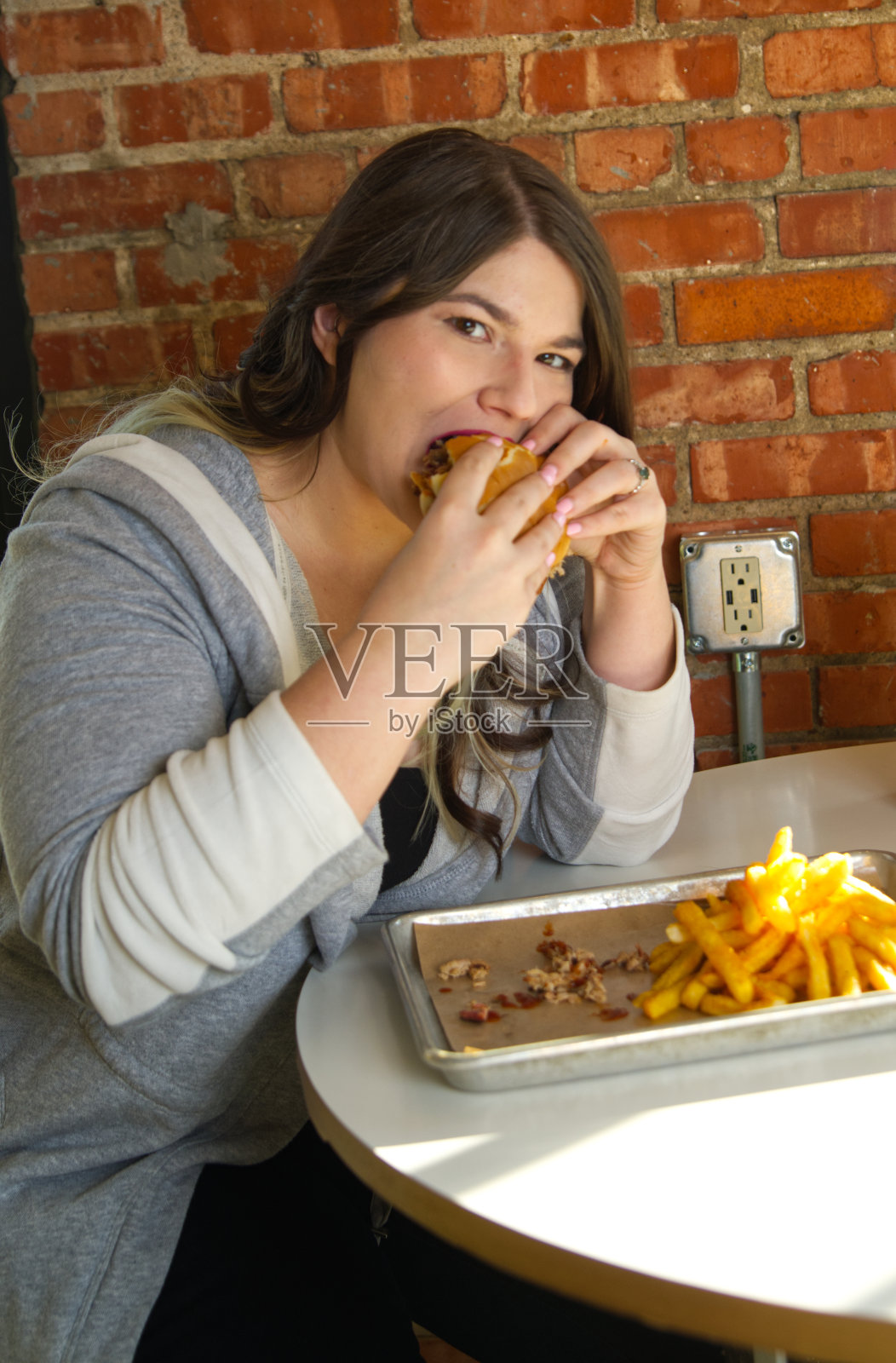吃烧烤三明治的女人看着镜头照片摄影图片