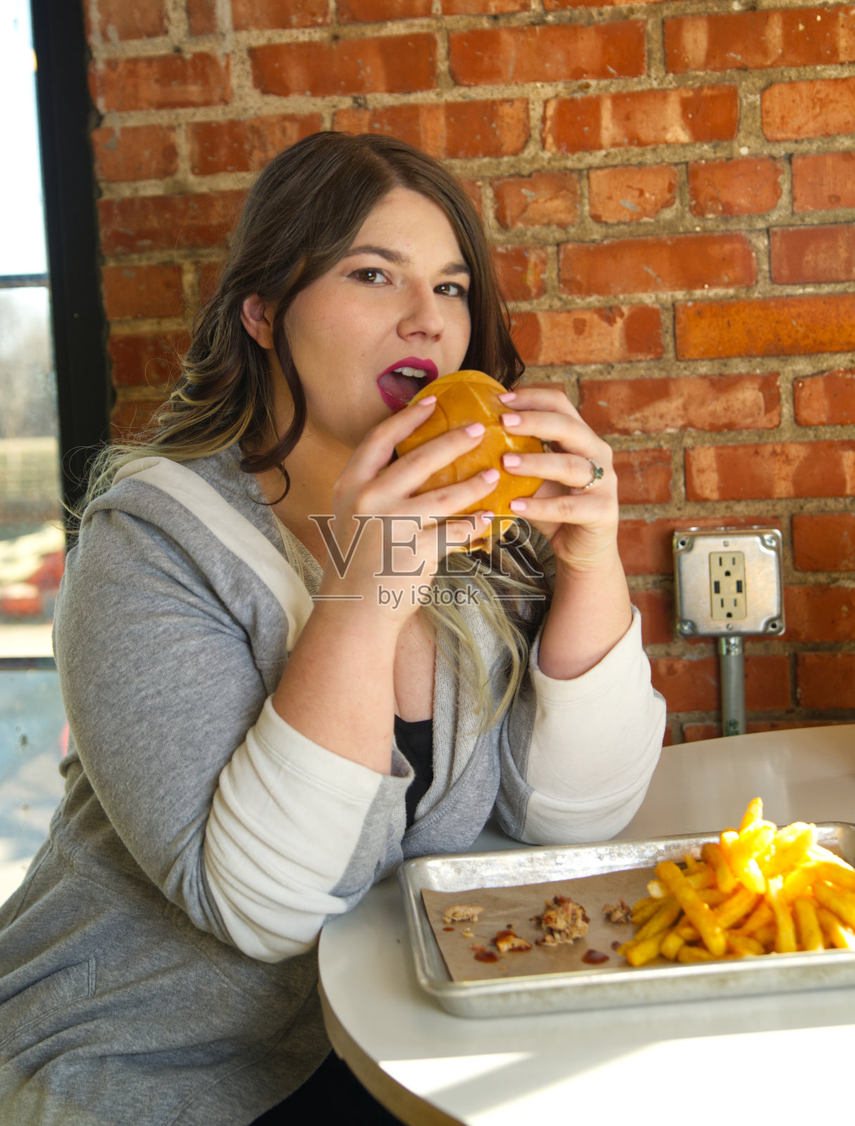 一个女人正要咬一口烧烤三明治照片摄影图片