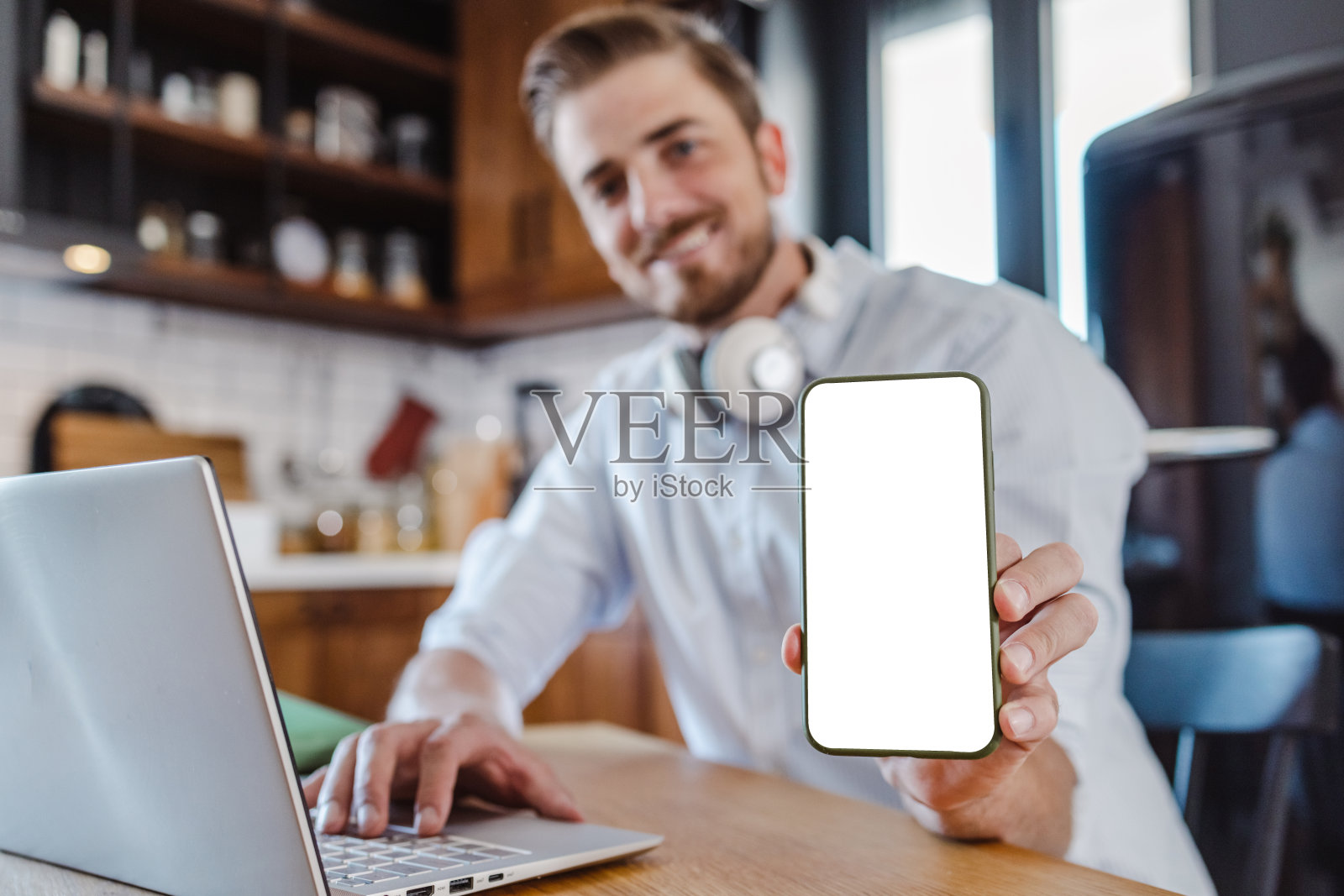 年轻人正在展示空白屏幕的智能手机照片摄影图片