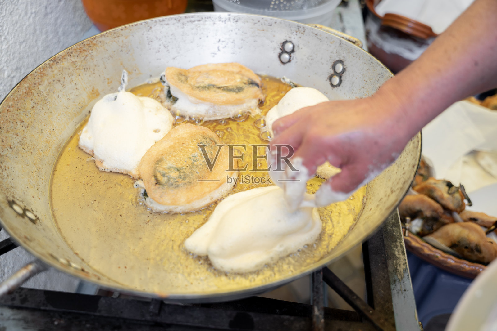 一位西班牙裔成年妇女正在一个金属锅里煎炸了的波布拉诺辣椒照片摄影图片