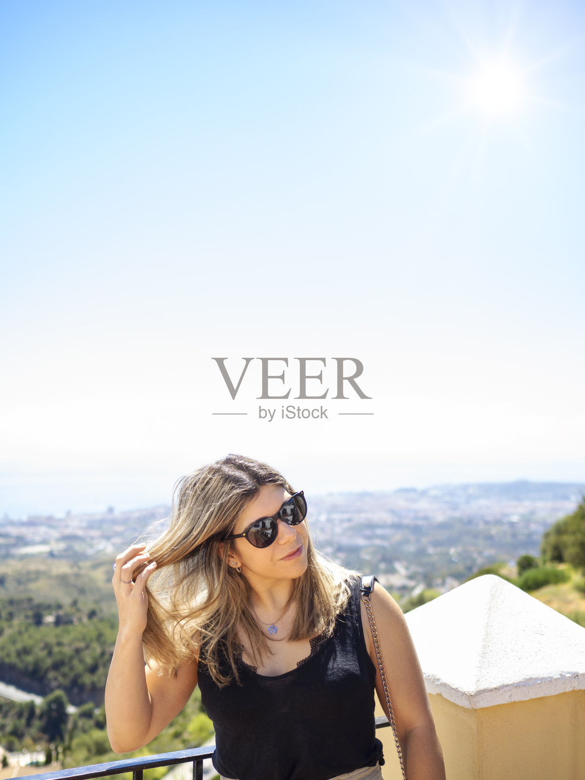 女人抚摸着自己的头发，在凉亭村讲述着旅游、度假、休闲的生活理念。照片摄影图片