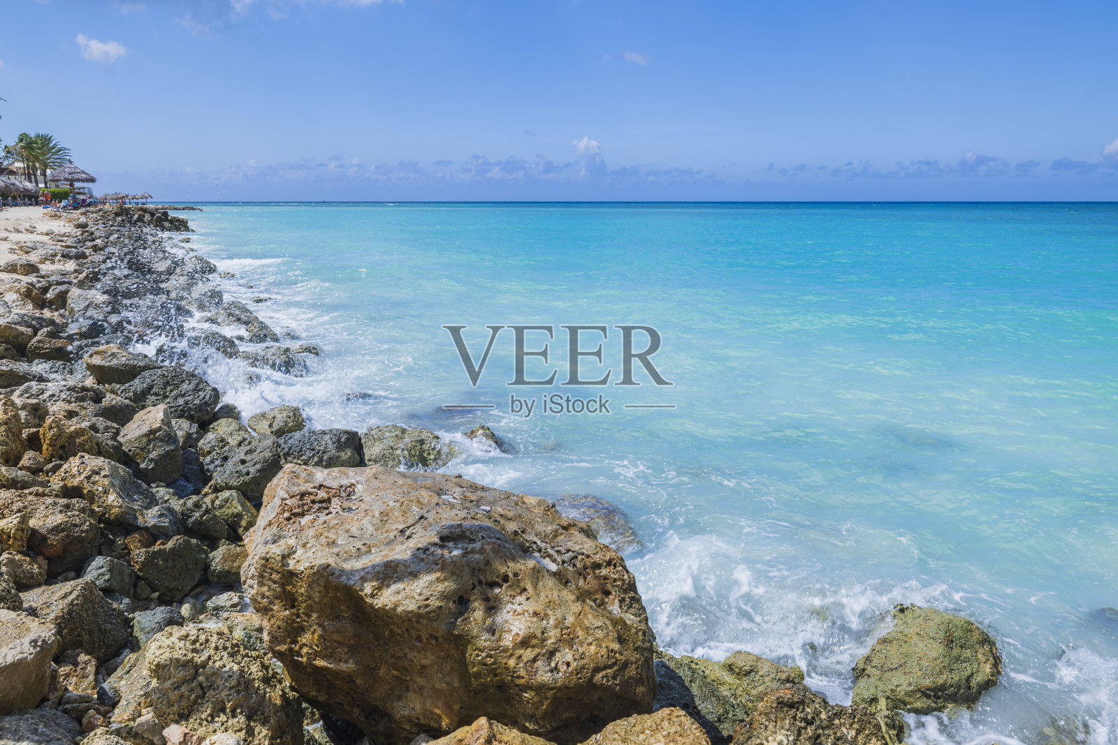 美丽的大西洋景色与蓝绿色的水在阿鲁巴岛与传入的海浪在岩石海岸。照片摄影图片