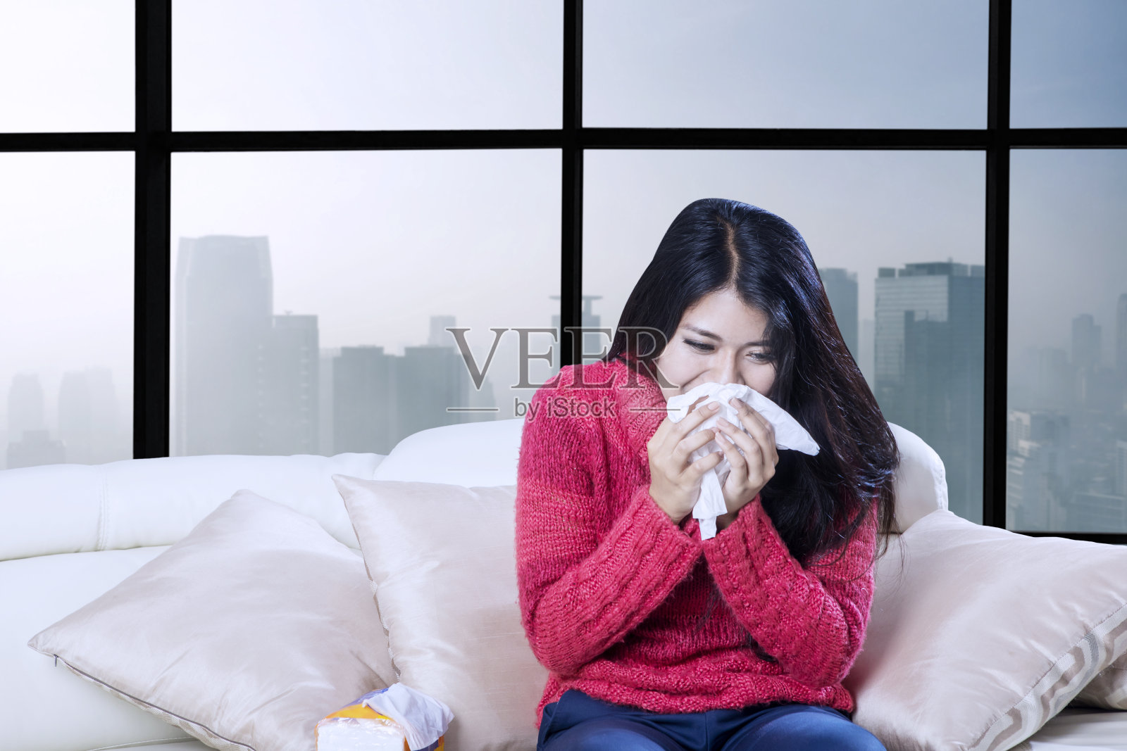 生病的女人用纸巾擤鼻涕照片摄影图片