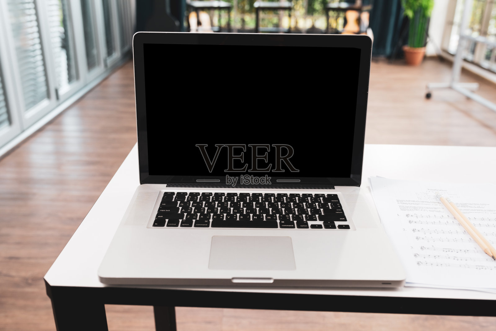 笔记本电脑的正面视图在会议室的工作桌上。照片摄影图片