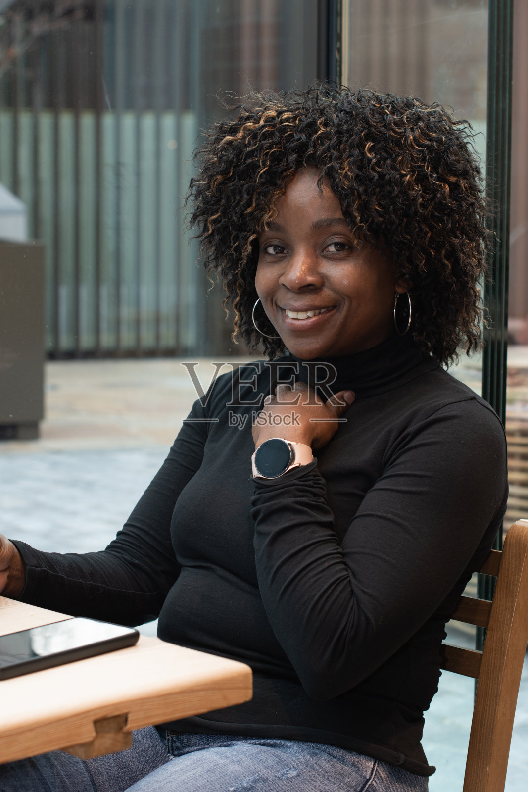 大清早，素颜的非裔美国女人在咖啡馆用智能手机聊天照片摄影图片