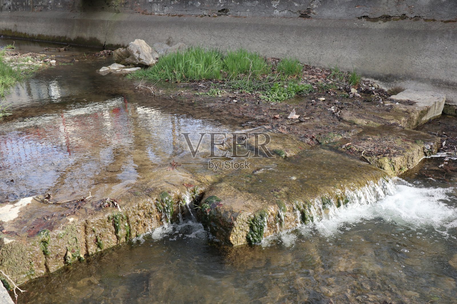 村子里的小溪从一个浅台阶上流过照片摄影图片