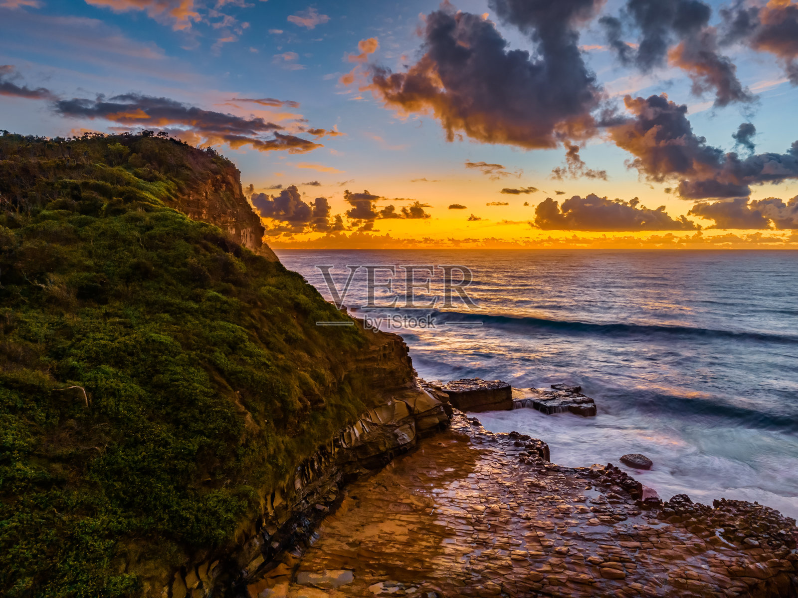 日出和云在海洋和岩石平台照片摄影图片