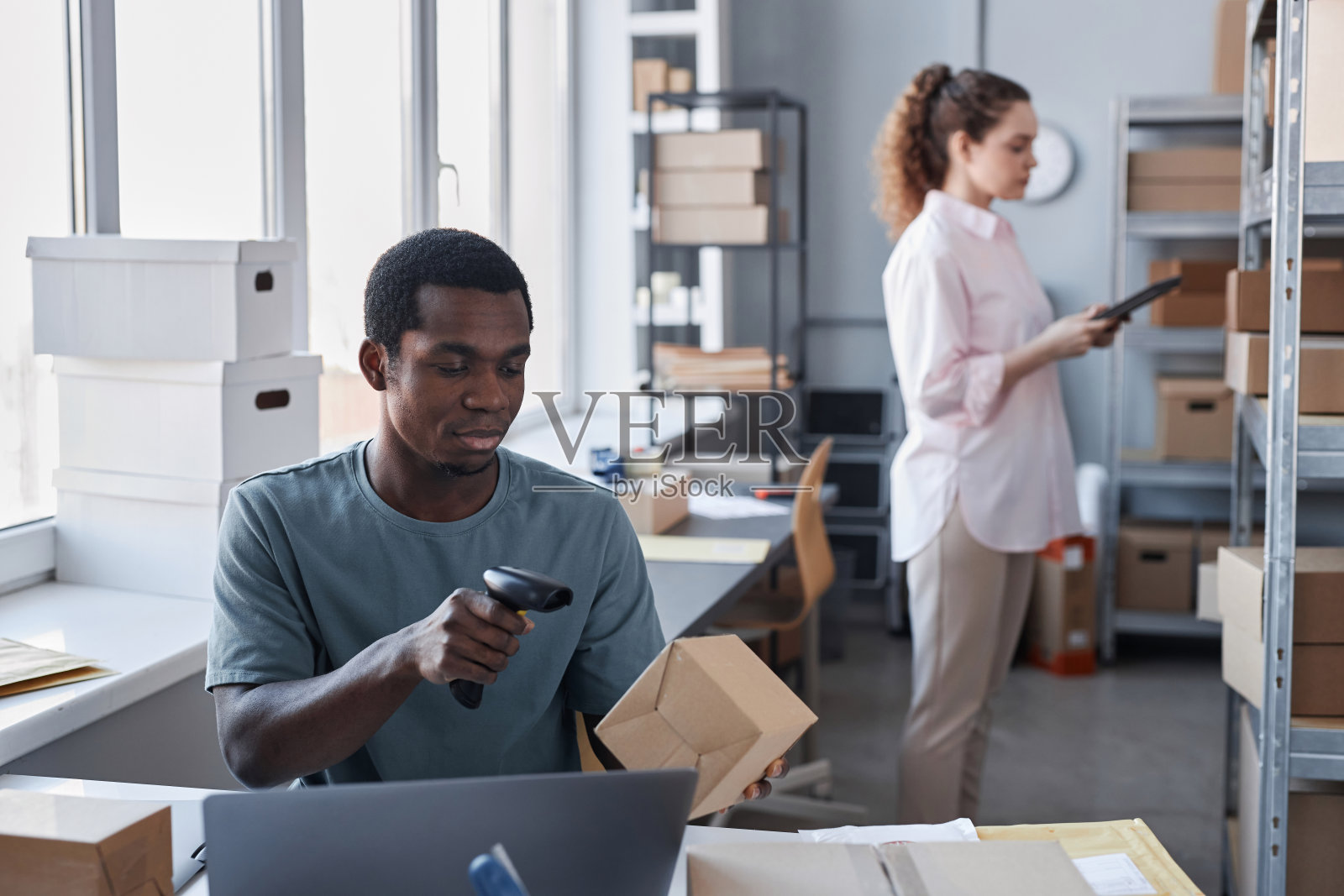 年轻的非裔美国人扫描纸板箱上的代码照片摄影图片