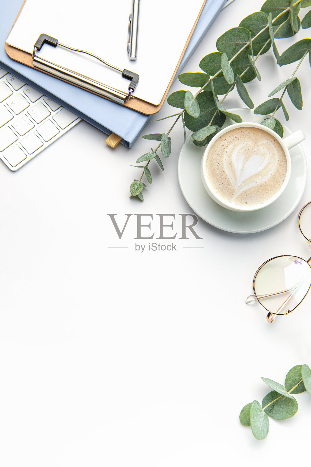 现代白色办公桌椅配有笔记本电脑、笔记本等用品。照片摄影图片