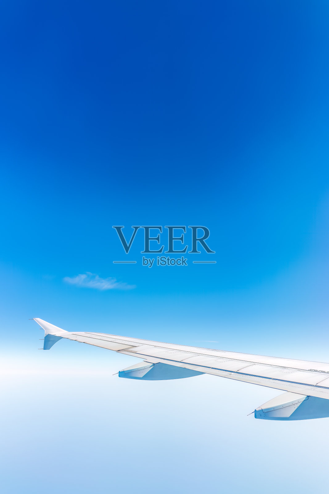 从飞机窗口看到美丽多云的天空和飞机的机翼照片摄影图片