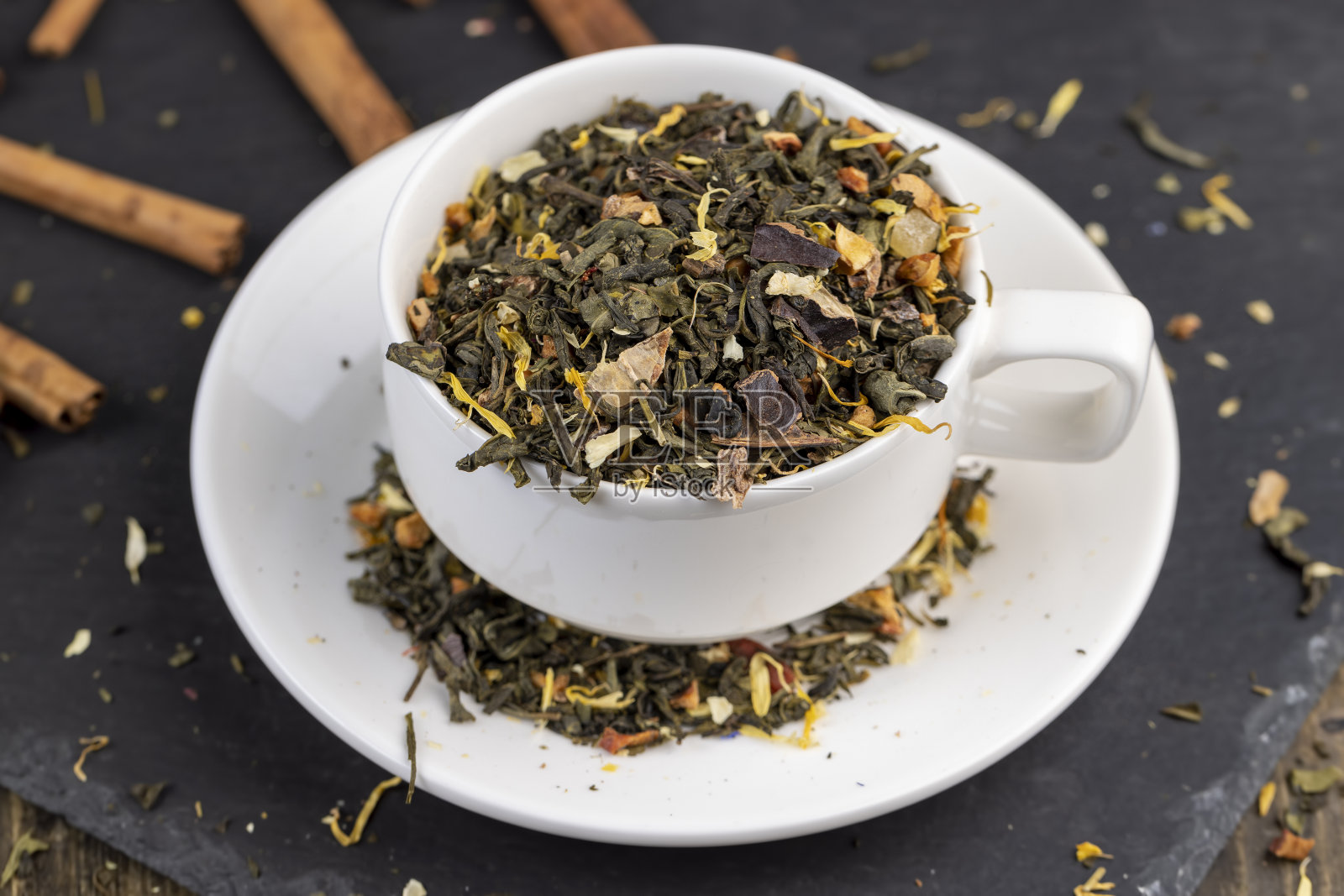 把干绿茶倒进白色杯子里照片摄影图片