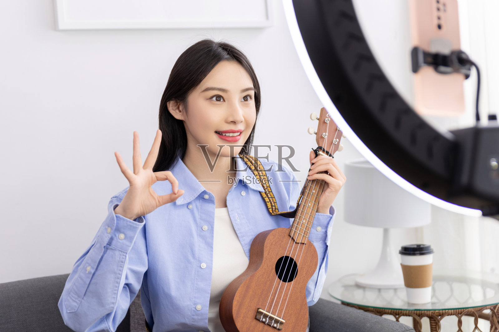 年轻女子在家里用笔记本电脑学习在线尤克里里吉他课程。学习一种乐器。照片摄影图片