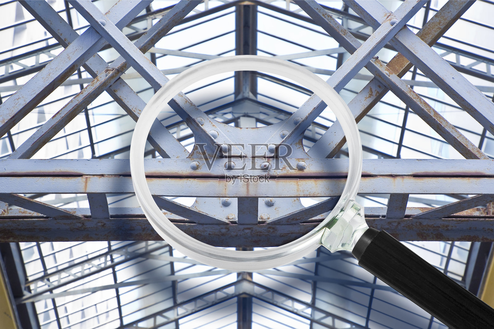 对旧钢结构的关注和监视-通过放大镜看到旧梁和金属轮廓的概念照片摄影图片