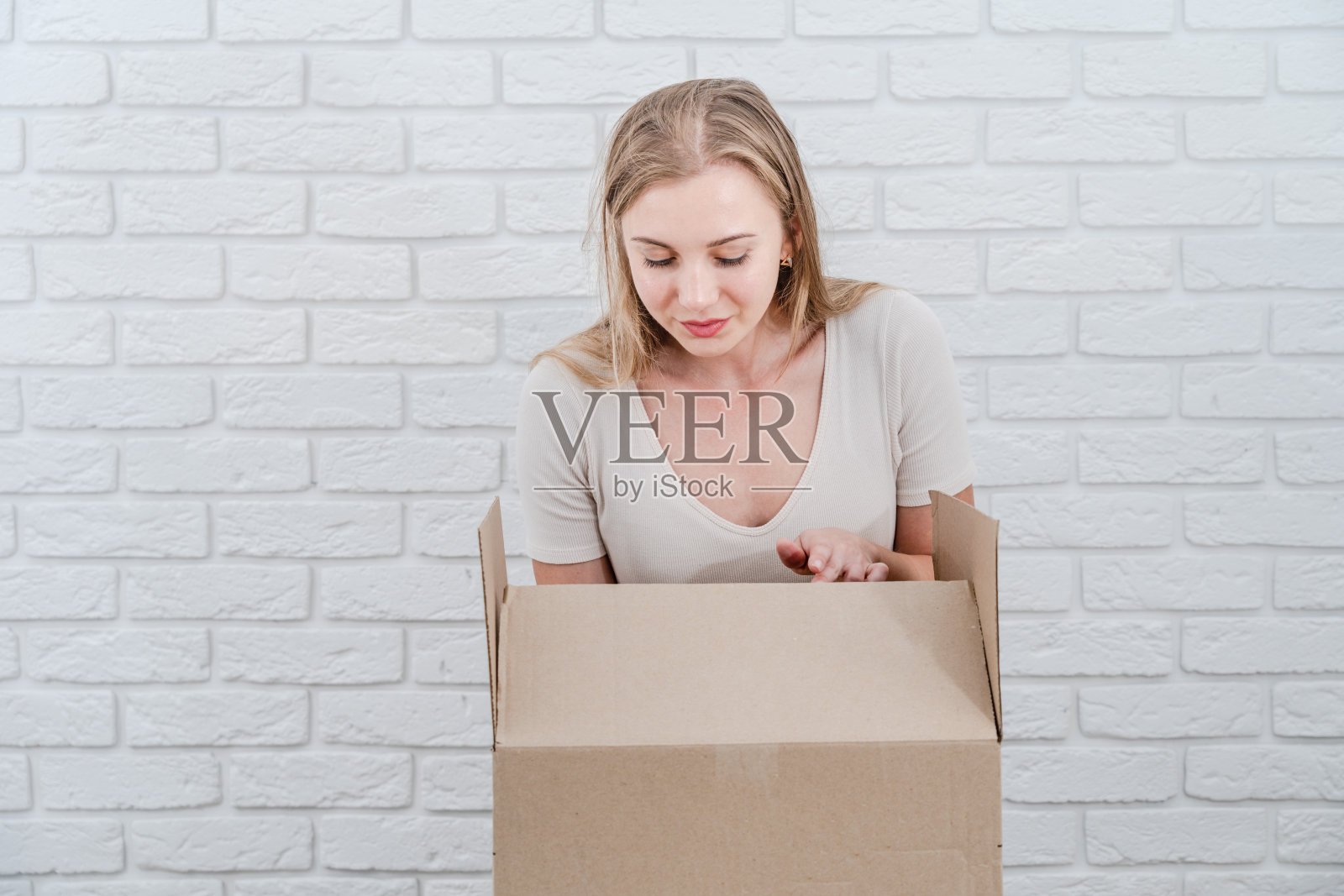 漂亮女人拿着打开的纸板箱。投递包裹照片摄影图片