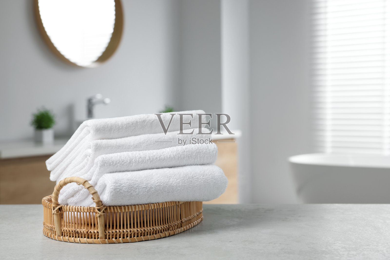 浴室桌子上的柳条篮子和白毛巾。文本空间照片摄影图片