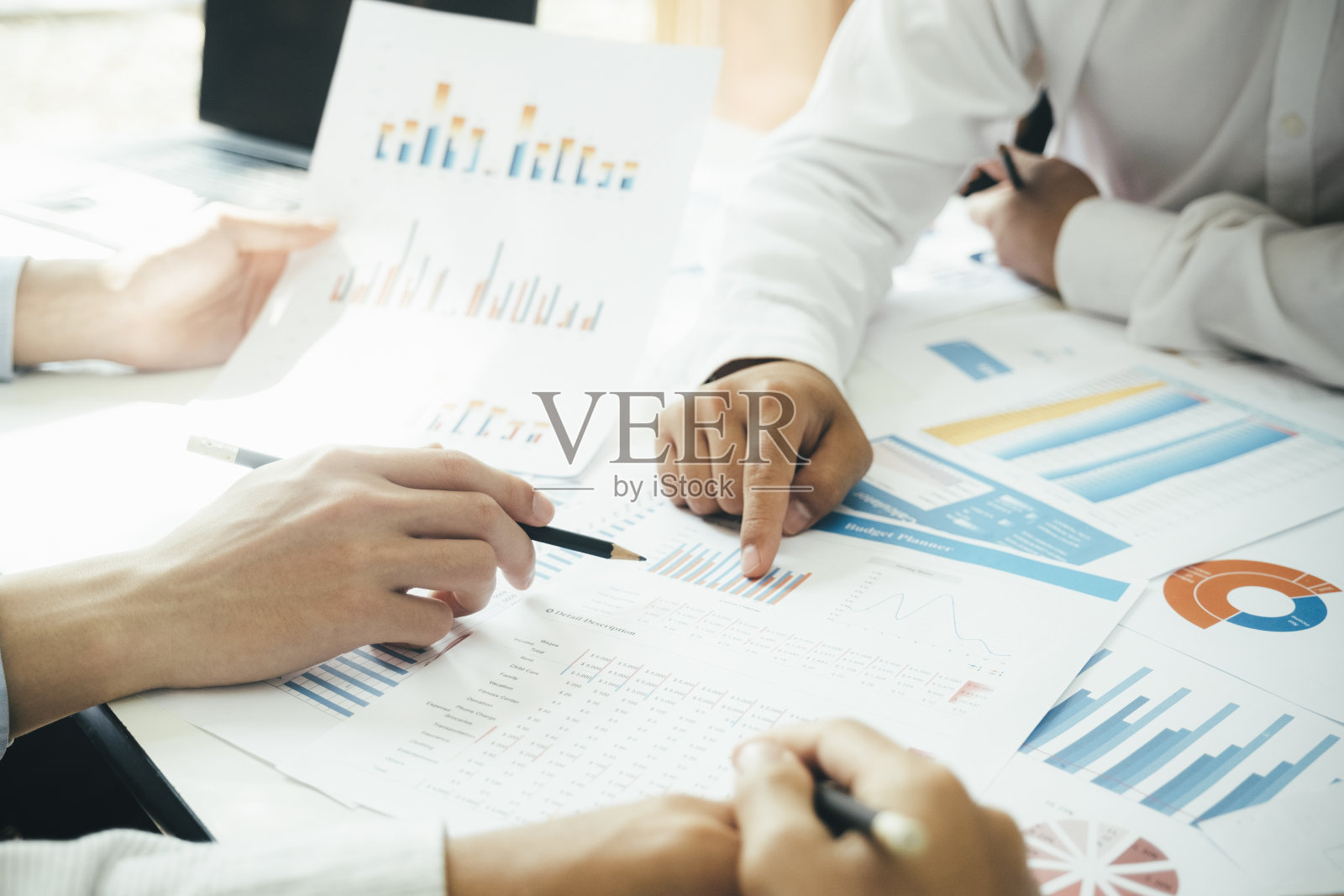 在办公桌前一起工作的商人。照片摄影图片