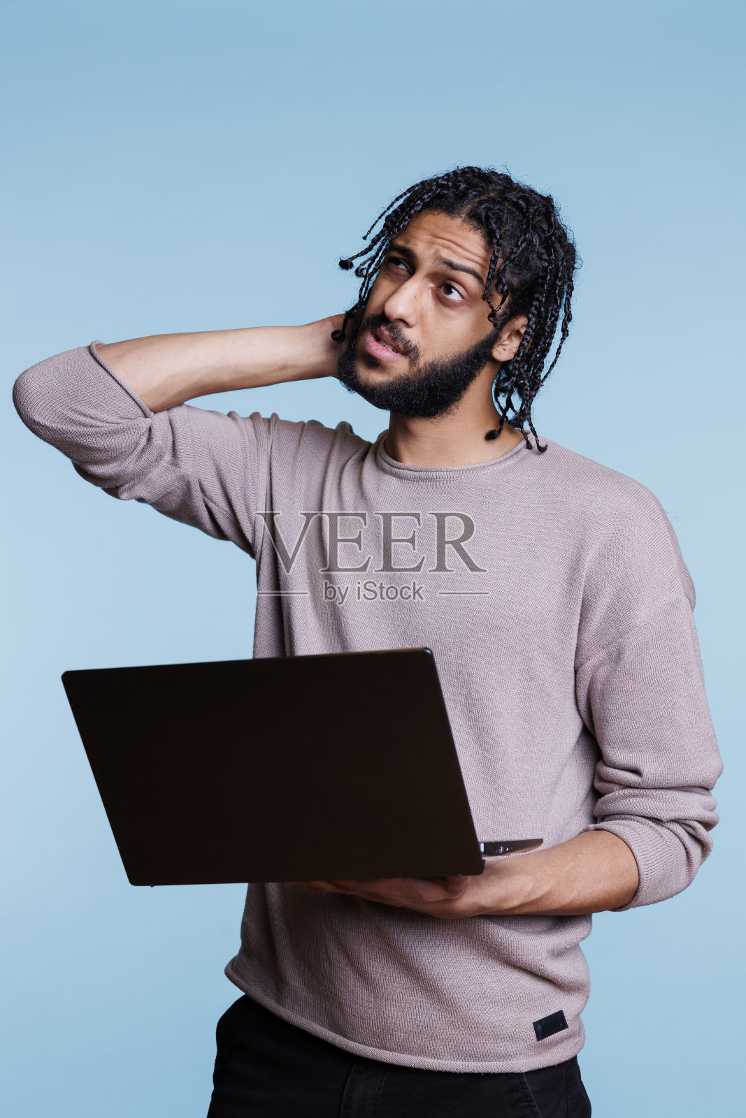 拿着笔记本电脑的阿拉伯程序员，不确定软件应用程序的开发照片摄影图片