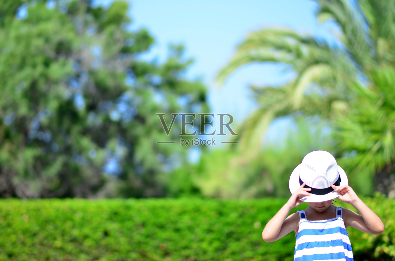 戴着帽子向下看的小女孩照片摄影图片