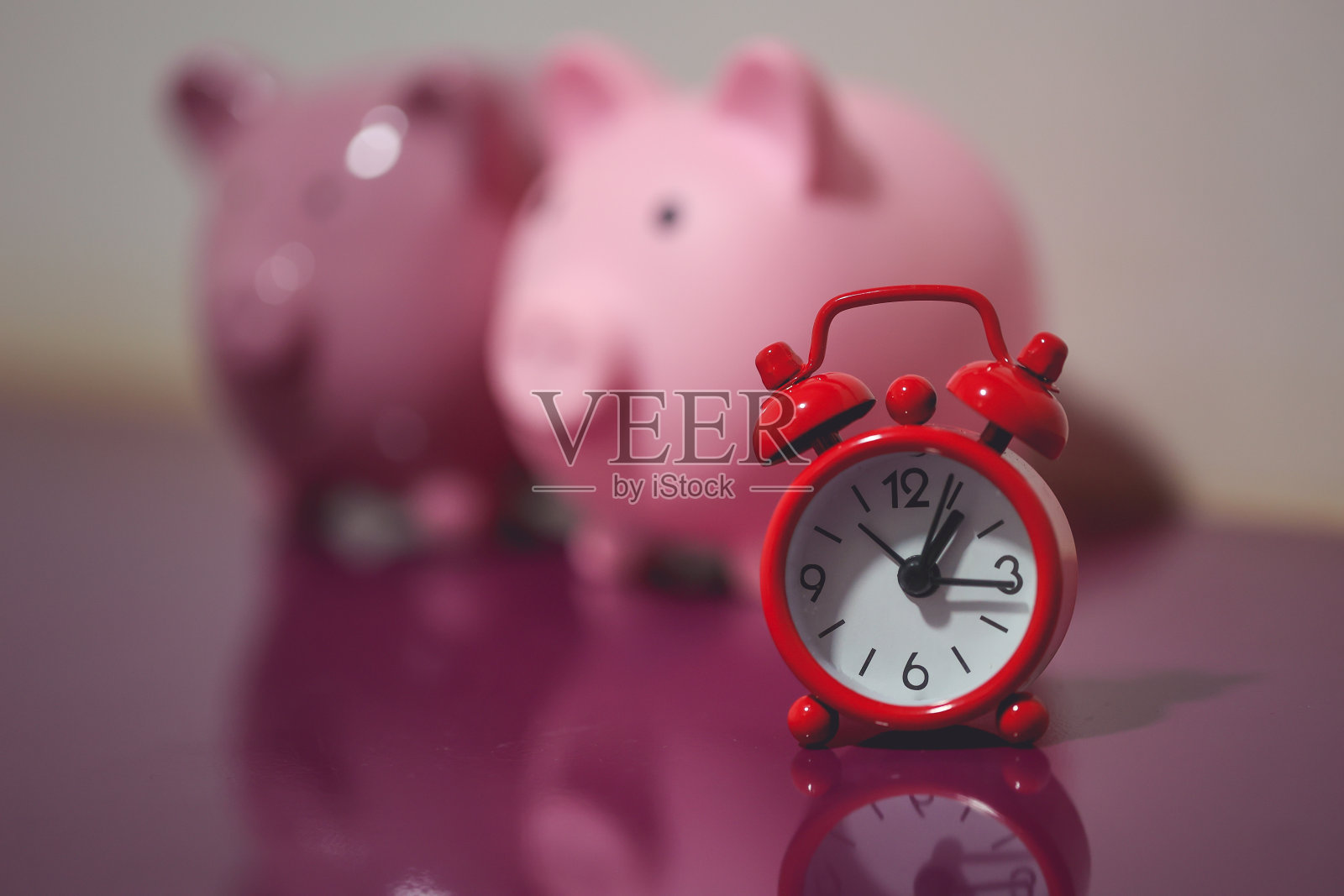 两个储蓄罐和一个红色闹钟。金融的概念。照片摄影图片