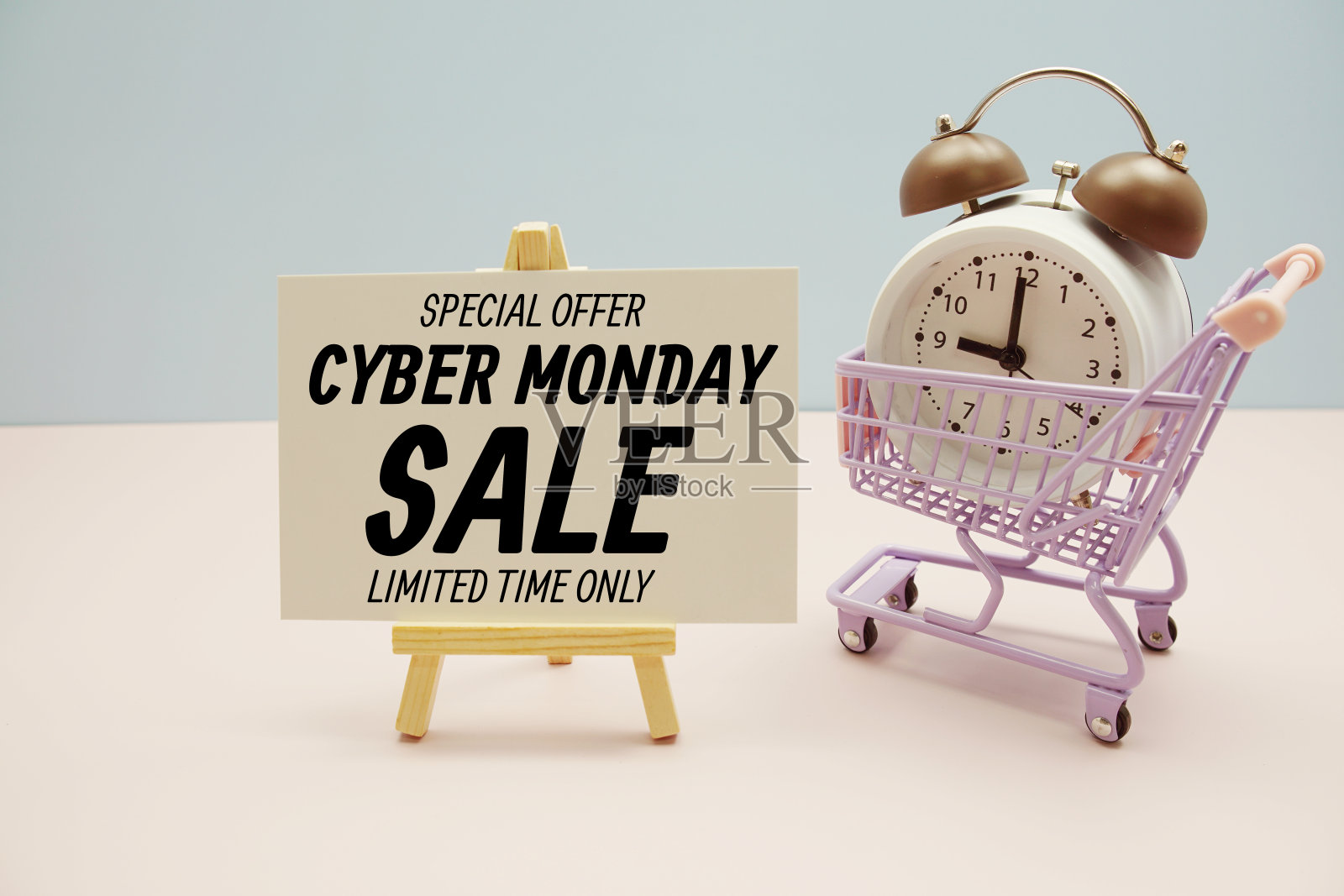 网络星期一促销短信，以粉红色和蓝色为背景，配有闹钟和购物车照片摄影图片