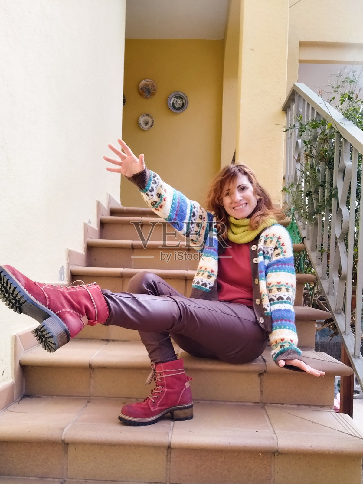 秋天里，年轻的女孩坐在楼梯上，伸开一条腿照片摄影图片