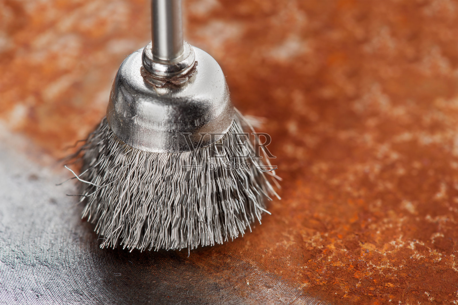 钻头用钢刷清除带锈的旧金属片照片摄影图片