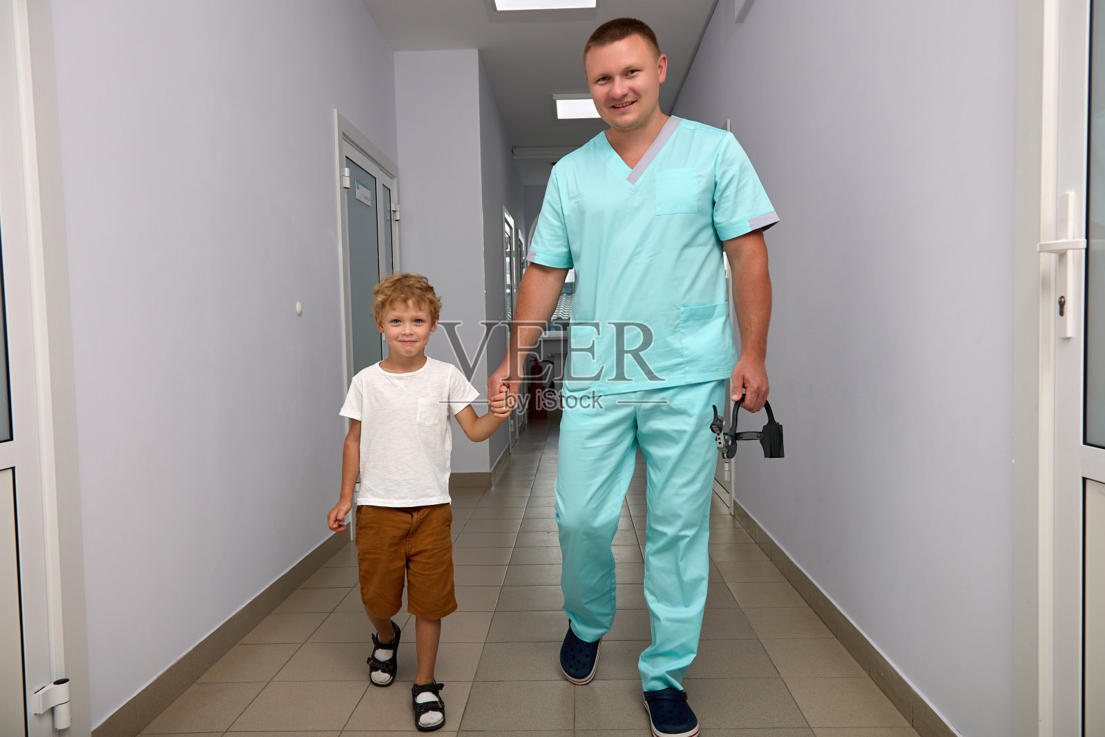 儿科医生带着仪器把小病人带到办公室检查照片摄影图片