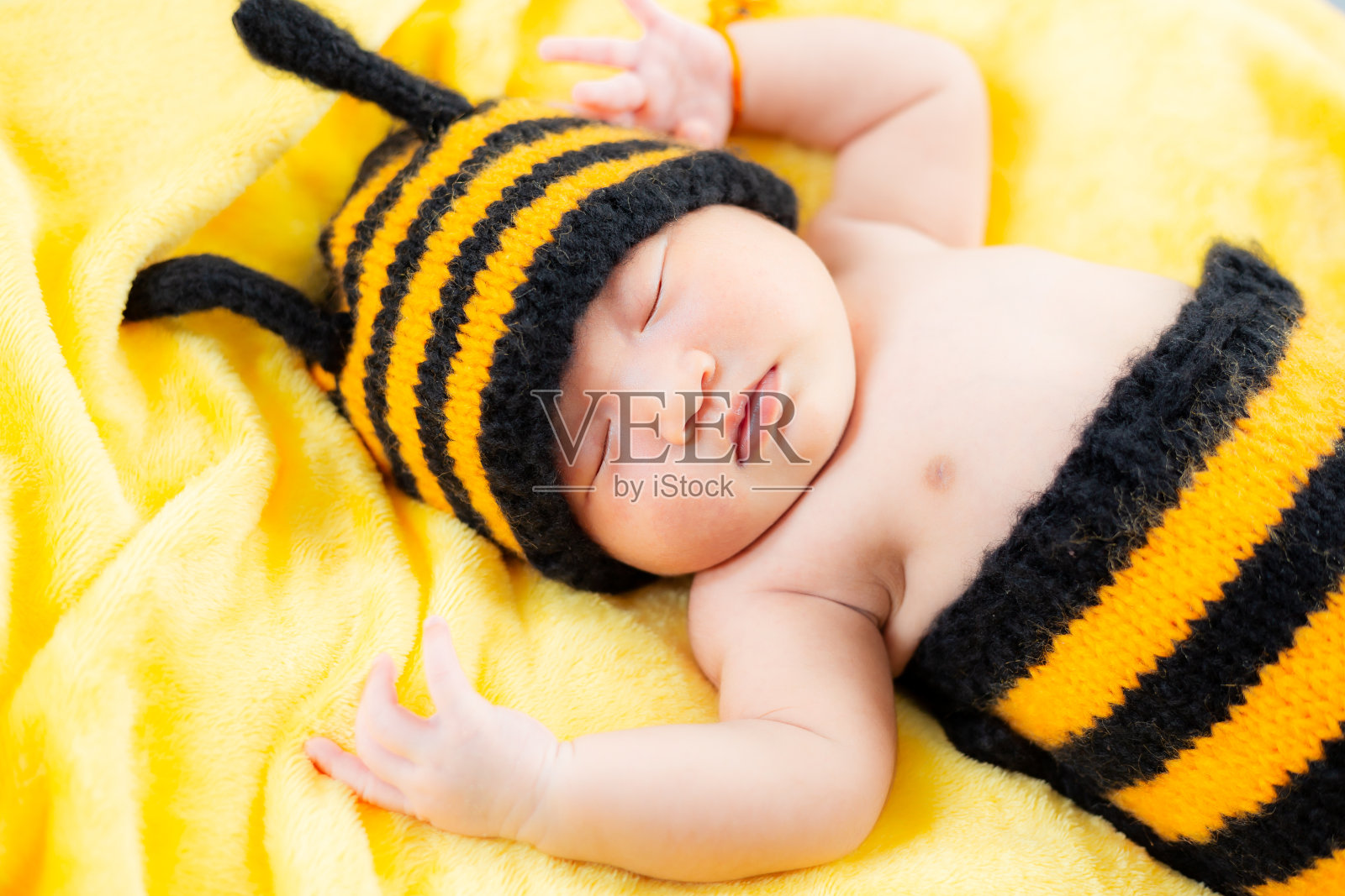 亚洲女婴穿着蜜蜂服装，婴儿穿着蜜蜂服装，新生儿穿着蜜蜂服装。新生儿概念照，照片摄影图片