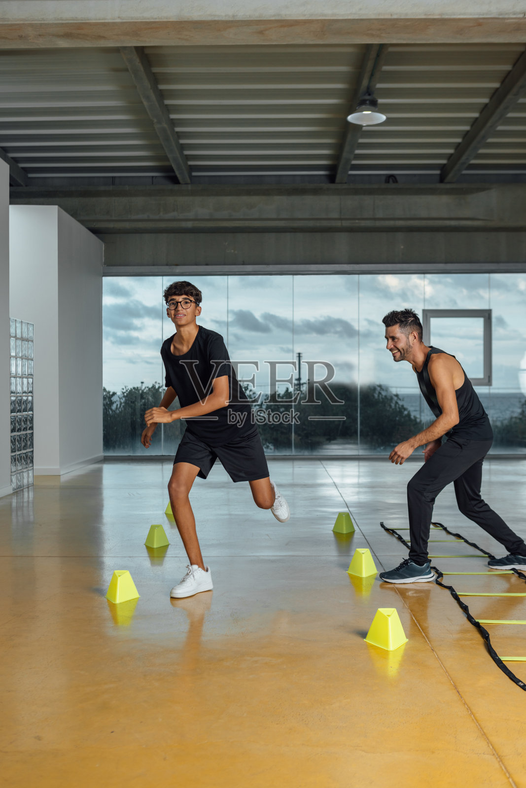 私人教练鼓励男孩在健身房进行例行的巡回训练照片摄影图片