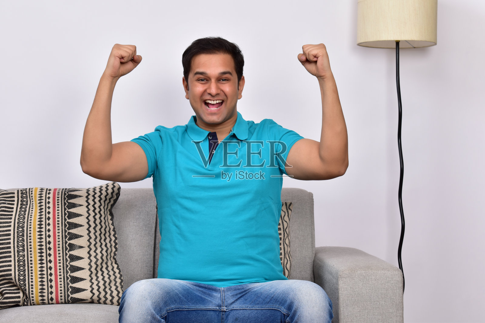 快乐的年轻人坐在家里的沙发上照片摄影图片