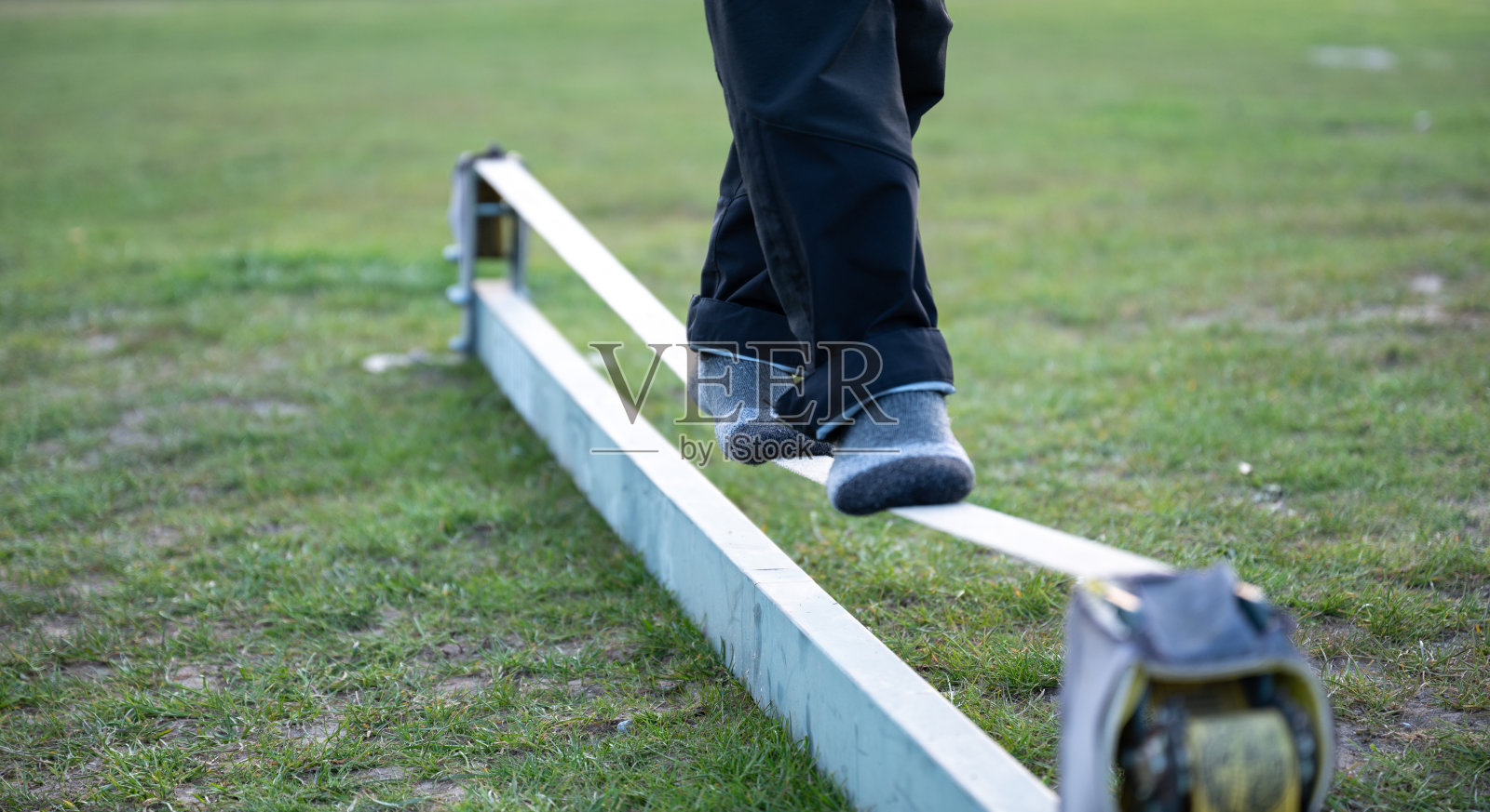 双脚在一根松弛的绳子上保持平衡。寻找平衡，平衡训练这一潮流运动照片摄影图片