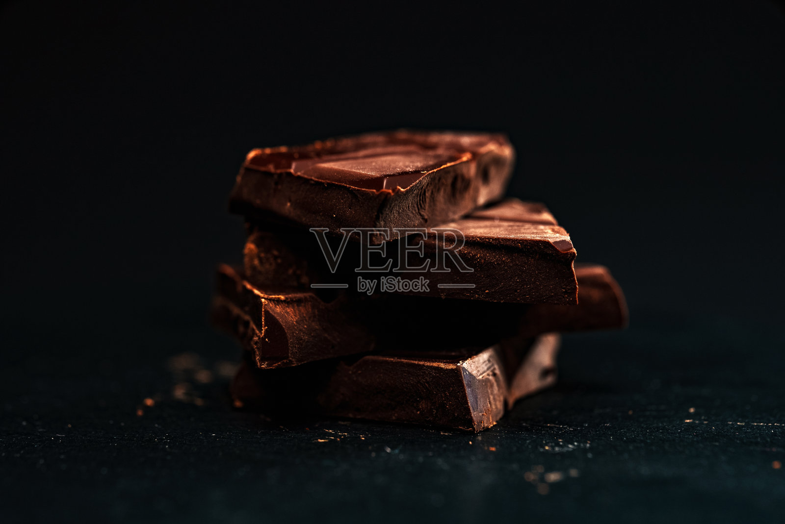 碎黑巧克力条叠在桌子上。照片摄影图片