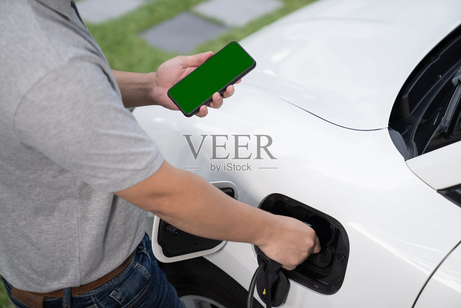 进步概念的绿屏样机手机、电动汽车和充电站。照片摄影图片