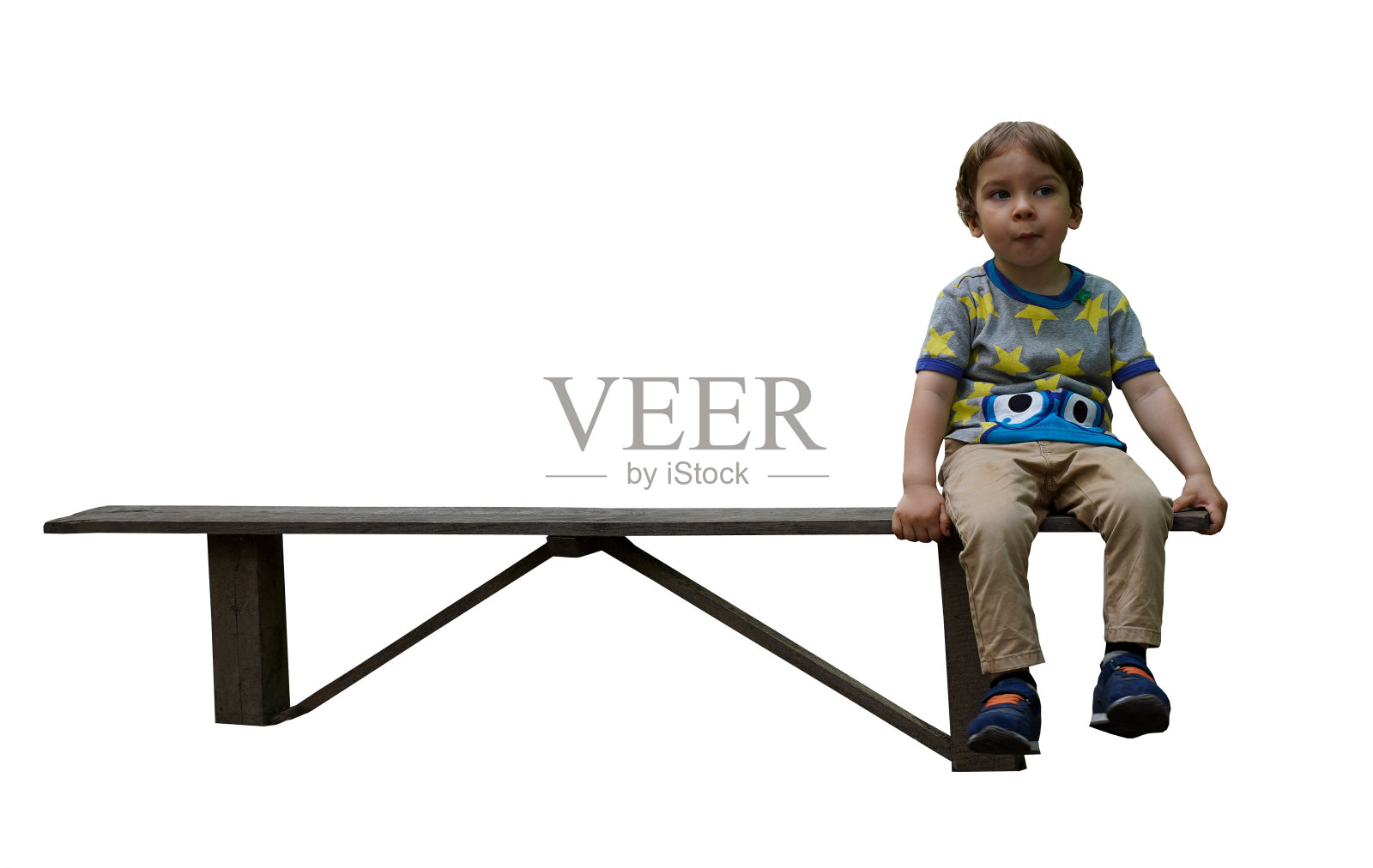 一个小男孩独自坐在白色背景的长凳上。有选择性的重点照片摄影图片