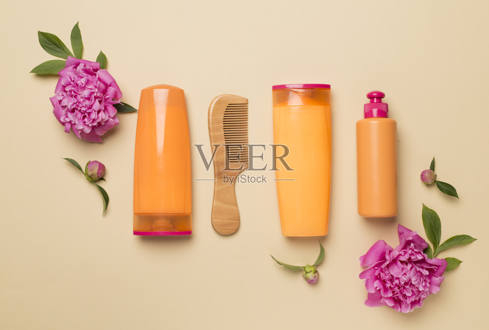头发护理产品与牡丹花和梳子的颜色背景，俯视图照片摄影图片