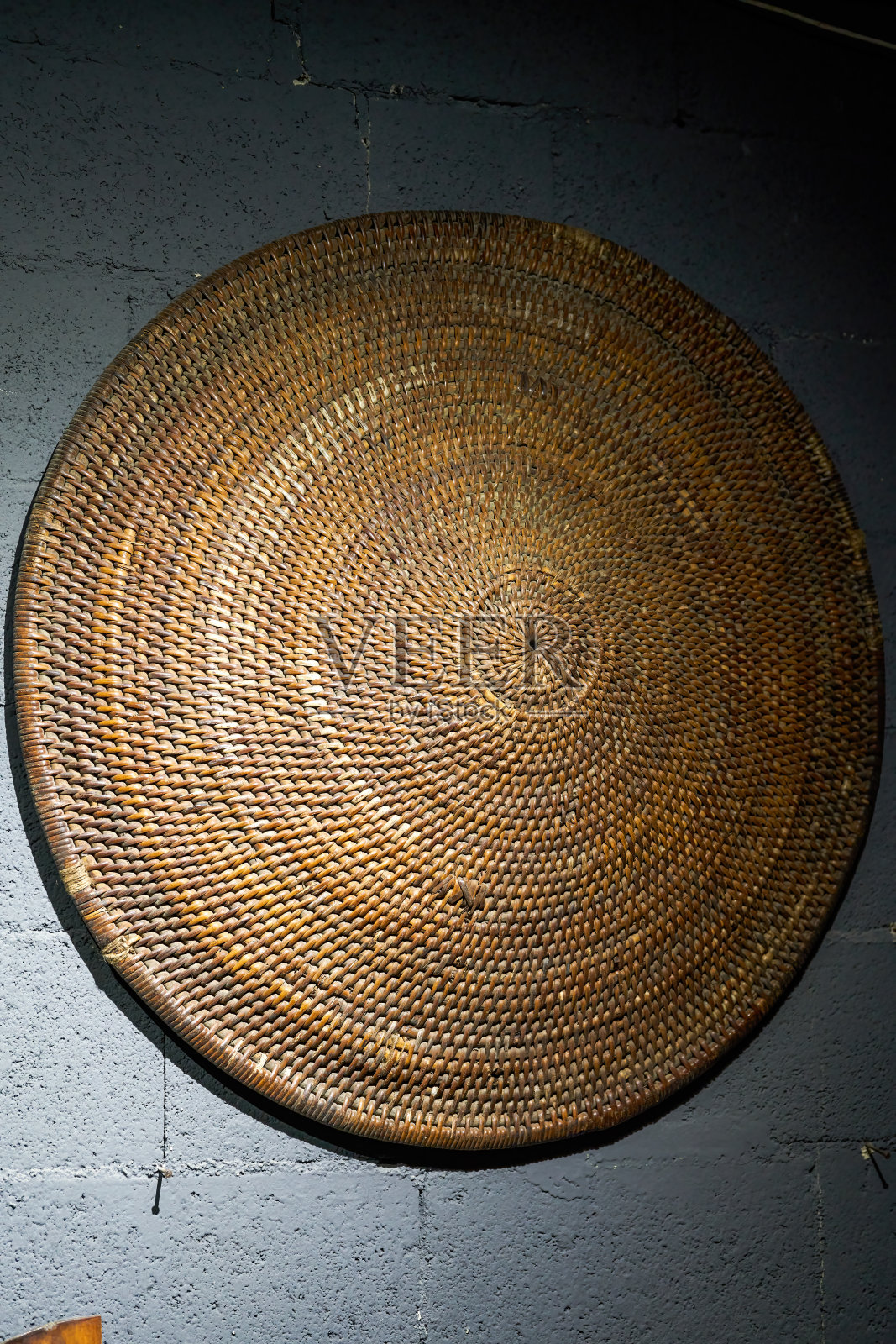 墙上挂着一个大簸箕的特写照片摄影图片