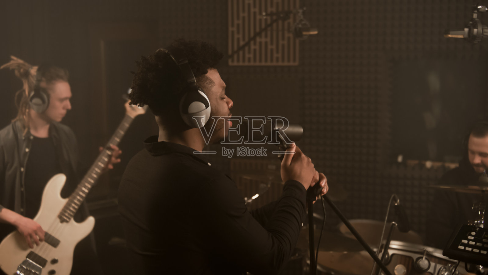 歌手将手放在麦克风支架上唱歌照片摄影图片