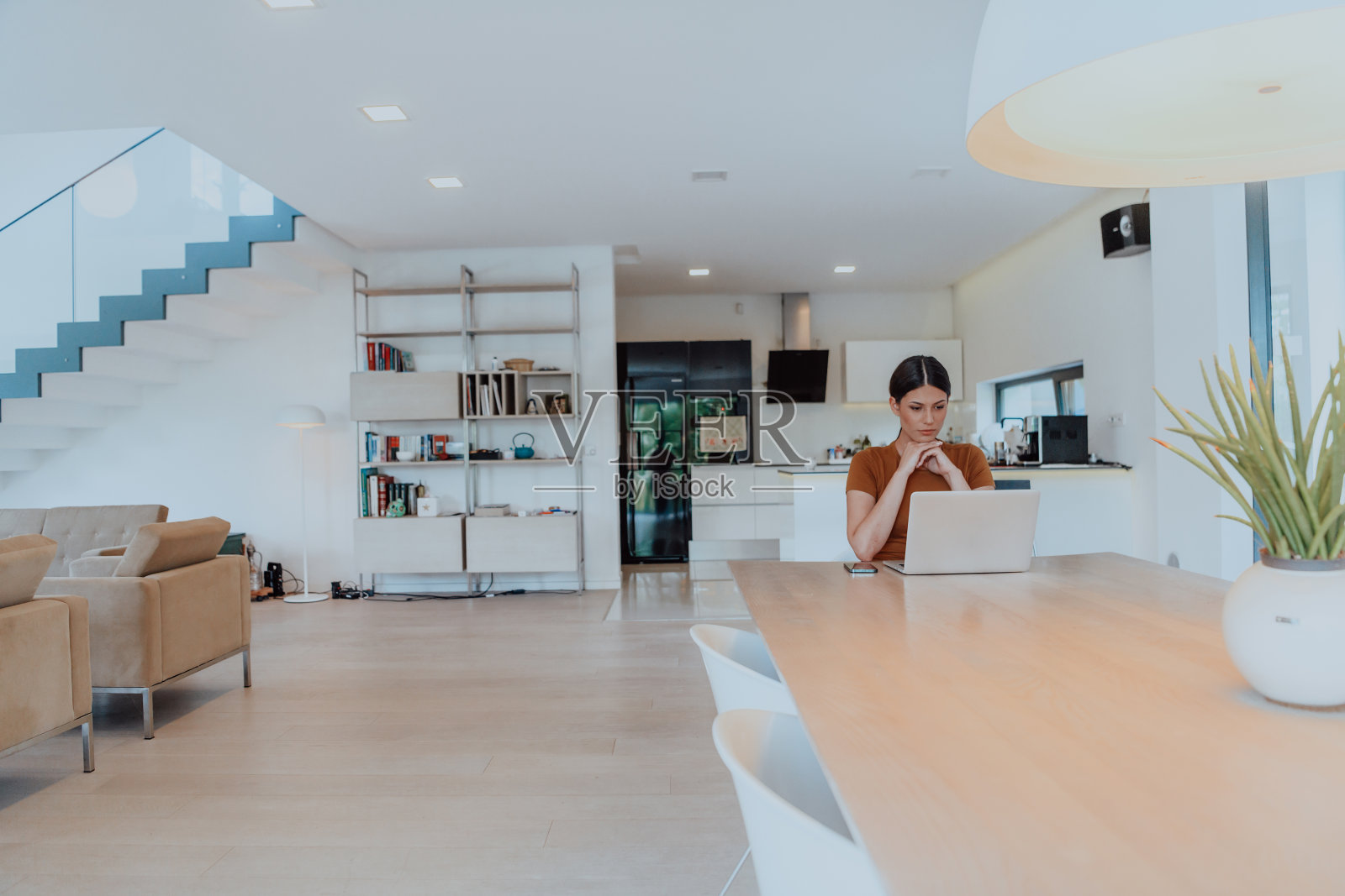 女人坐在客厅里，用笔记本电脑看摄像头，和生意上的朋友亲戚视频通话，拍大头。工作面试回答问题。照片摄影图片