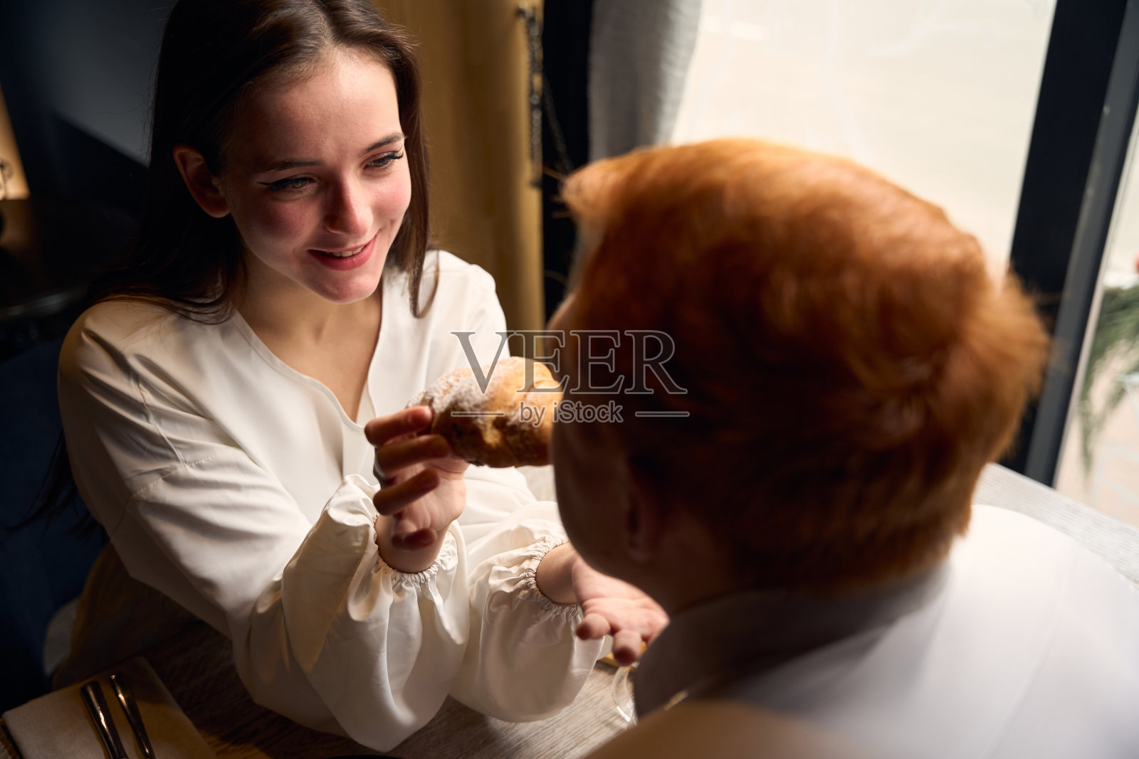 迷人的黑发女郎用手喂她的男朋友照片摄影图片