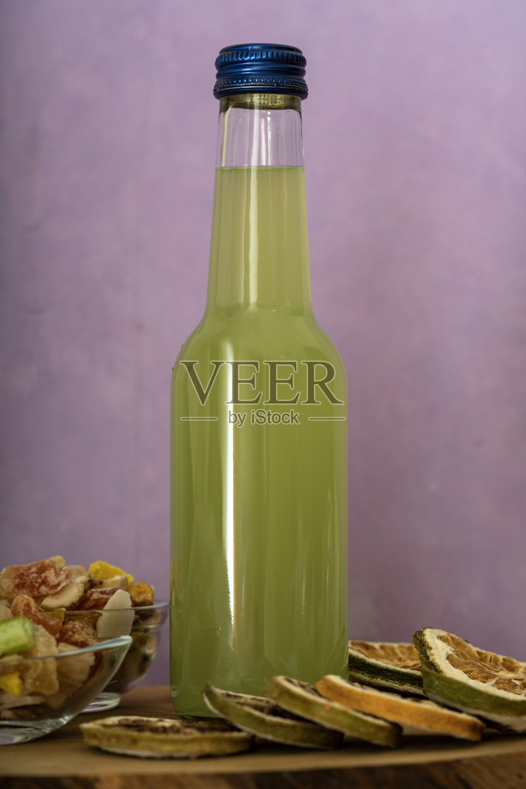 酸橙、柠檬、汤力水、伏特加和冰的冷鸡尾酒。石灰瓶子。照片摄影图片