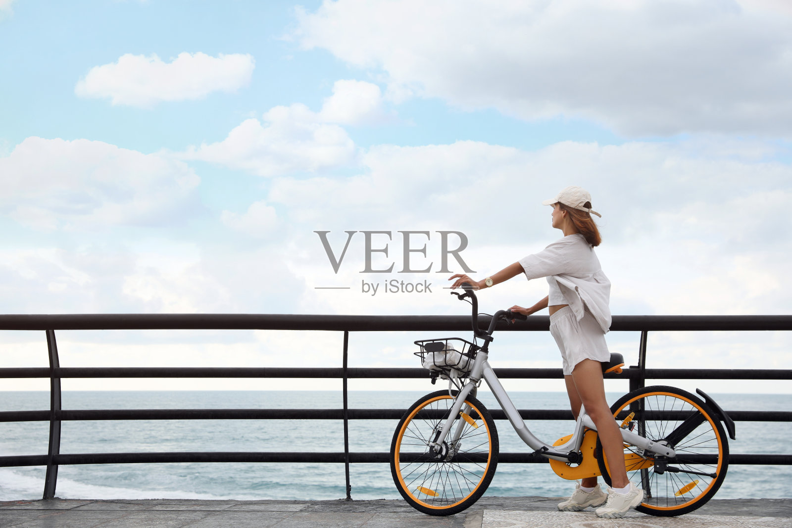 漂亮的年轻女子在海边骑自行车。文本空间照片摄影图片